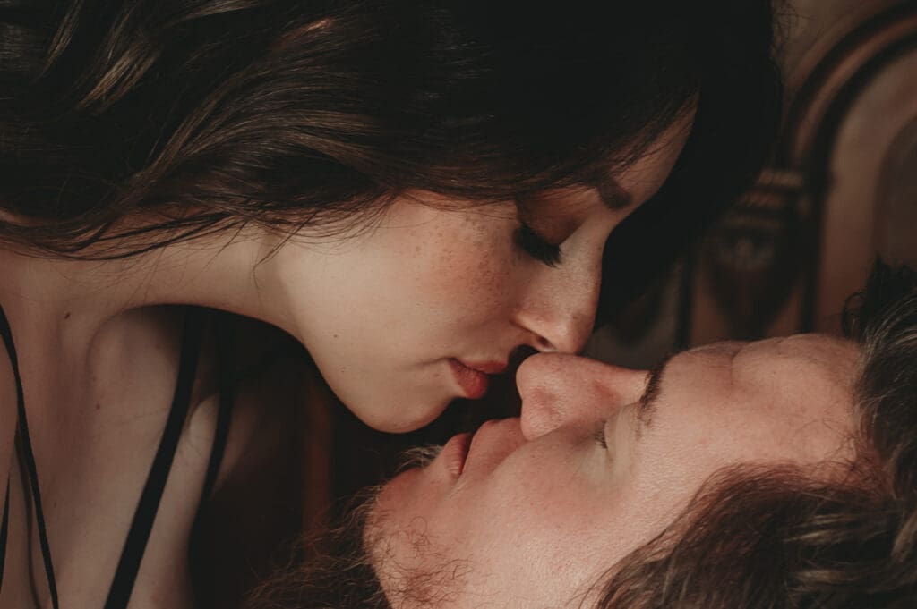 Close-up of a man and woman during their couples boudoir session at Helios Boudoir Photography, with their noses touching and eyes closed in anticipation of a kiss.