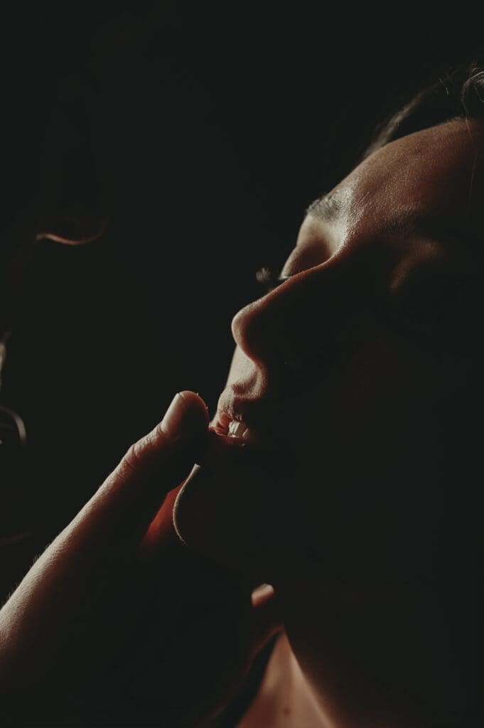 Close-up of an intimate moment during a couples boudoir session at Helios Boudoir Photography, featuring soft lighting and sensual connection.
